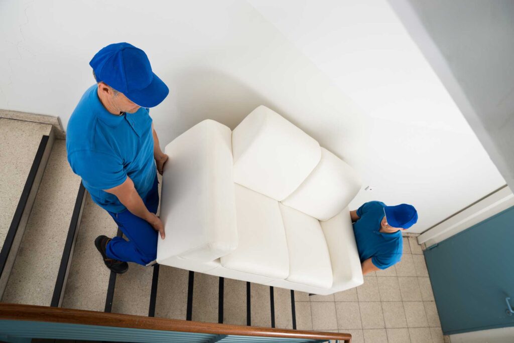 Removalists Carrying Sofa On Staircase