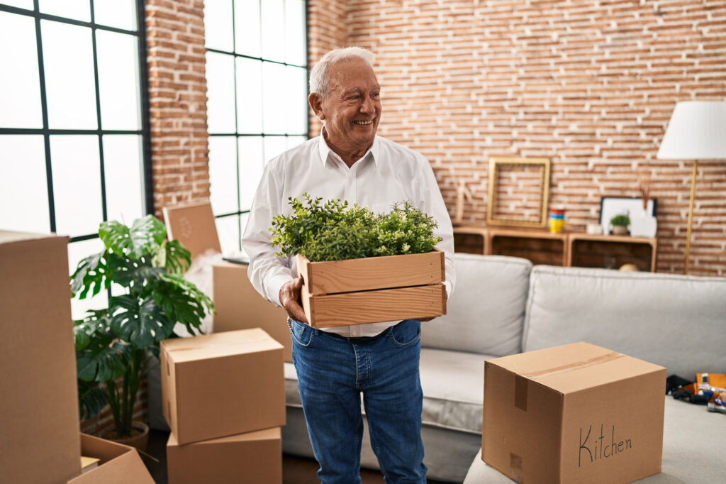 man holding plant pot at new home